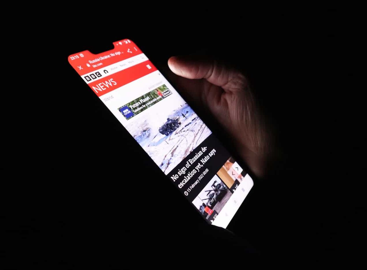 a person holding a cell phone in their hand